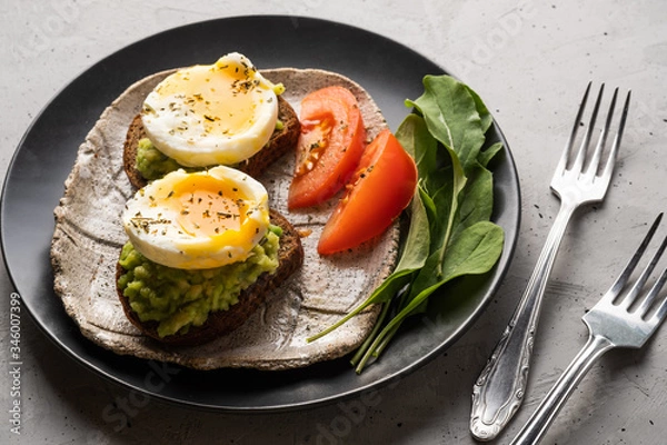 Obraz Sandwich with guacamole made of ripe avocados and poached egg. Healthy diet or vegetarian food  