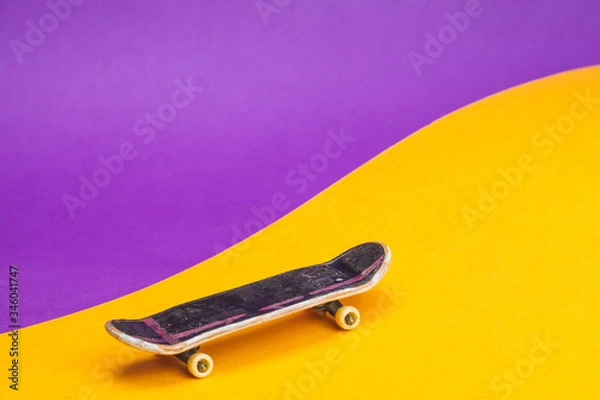 Fototapeta Small skateboard on color background. tiny skate for fingers. fingerboard close up. home leisure concept