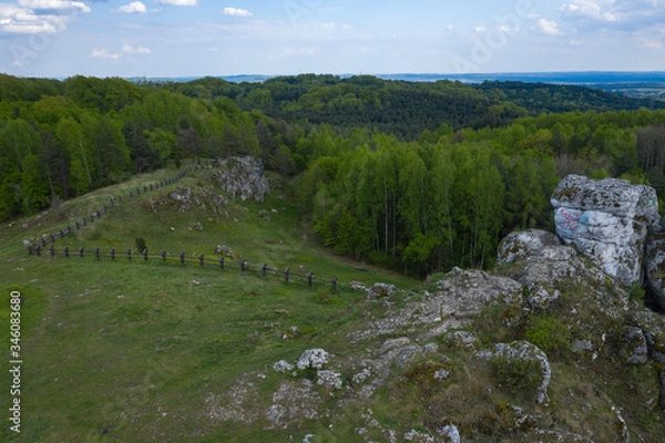 Fototapeta Aerial view of limestone rock formations in green located near Krakow in Poland. Shots from the drone showing the vast green hilly areas of the Cracow-Częstochowa highlands. Kraków-Częstochowa Jura.