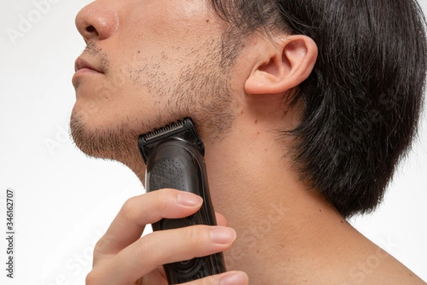 Obraz バリカンで髭の長さを整えている様子