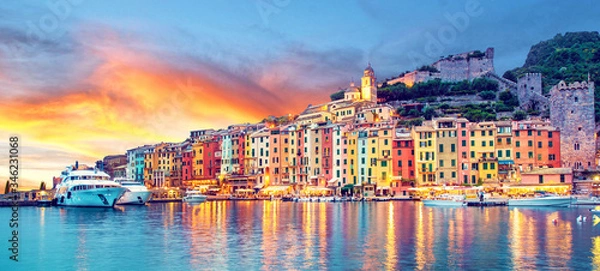 Obraz Mistyczny krajobraz portu z kolorowymi domami i łodziami w Porto Venere, Włochy, Liguria wieczorem w świetle latarni o zachodzie słońca