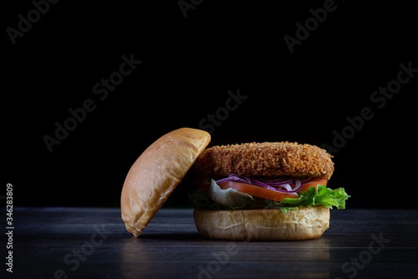 Fototapeta Chicken burger with lettuce, tomato, purpple onion and handmade mayo on the wood table. Delicious.