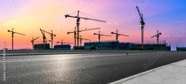 Fototapeta Empty asphalt road and construction site landscape at sunrise.