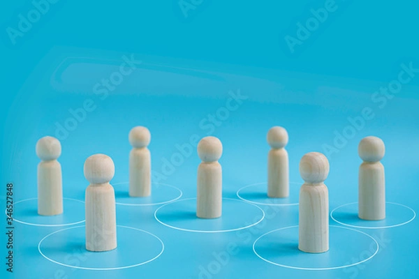 Fototapeta Wooden dolls on blue background with distance and protection circle line. people practice social distancing to protect from COVID-19 coronavirus spreading. Social distance preventing infection concept