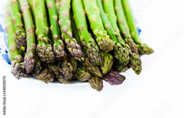 Fototapeta Bunch of fresh raw asparagus on white background, vegetarian concept. Green grass sparrowgrass sticks, food for veggie.