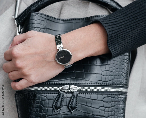 Obraz close-up hand of a girl with a clock on the background of a bag