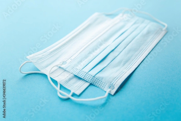 Fototapeta White and blue mask close-up on a blue background