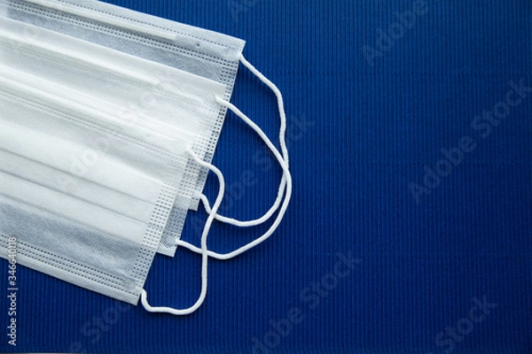 Fototapeta White masks on a dark blue background on the left.Empty background for notes on the right