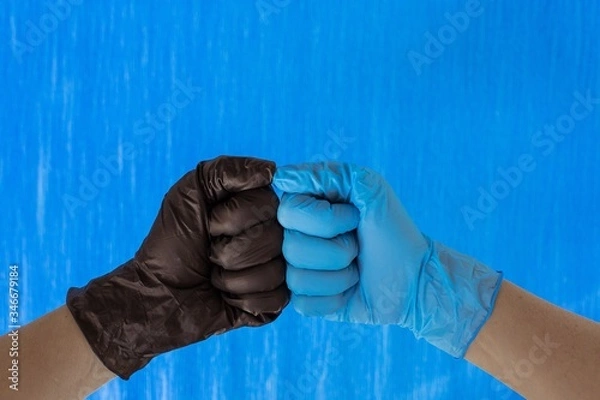 Fototapeta handshake in black and blue gloves isolated on blue background. Place for text. Copy space.