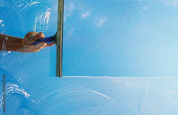Obraz Window cleaner cleans window with foam and puller