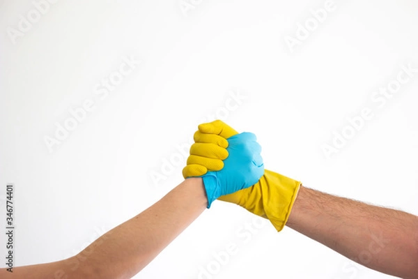 Obraz Caucasian woman and man hands and arms in blue and yellow latex gloves shacking hands isolate on white