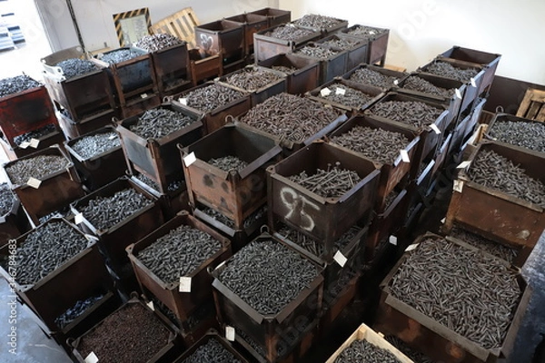 Fototapeta the raw material of the screw and machine producing bolts at the factory 