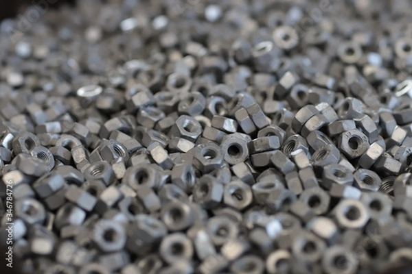 Fototapeta the raw material of the screw and machine producing bolts at the factory 