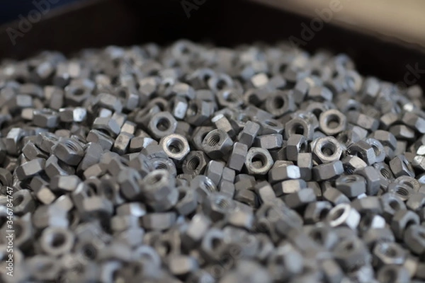 Fototapeta the raw material of the screw and machine producing bolts at the factory 