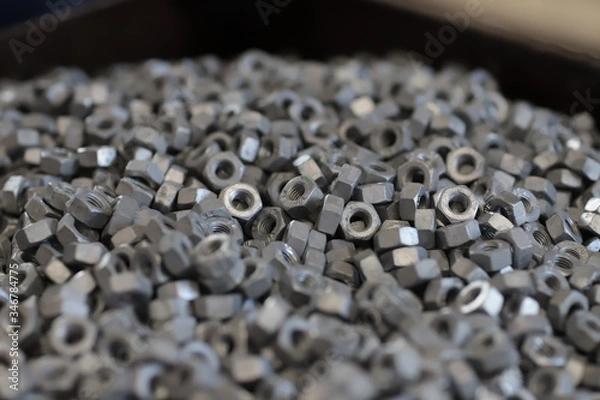 Fototapeta the raw material of the screw and machine producing bolts at the factory 