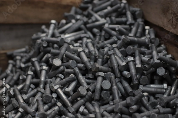 Fototapeta the raw material of the screw and machine producing bolts at the factory 