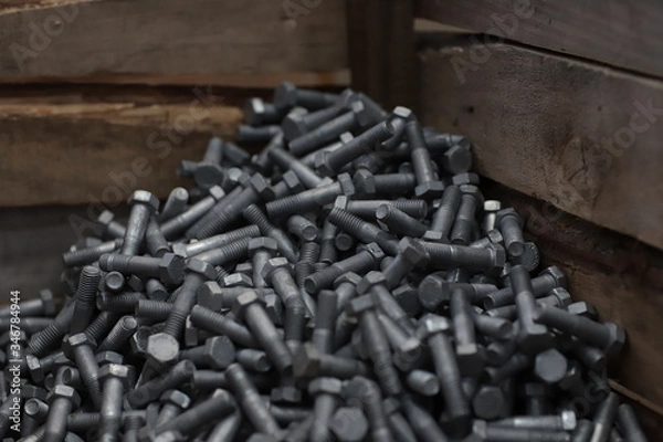 Fototapeta the raw material of the screw and machine producing bolts at the factory 