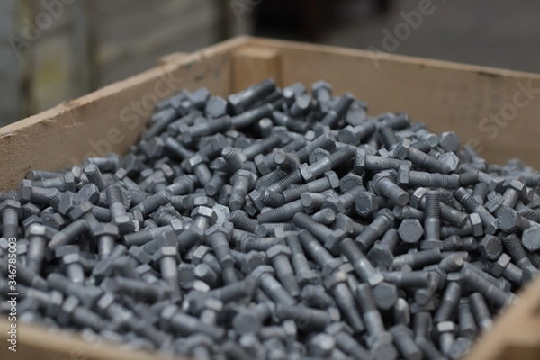 Fototapeta the raw material of the screw and machine producing bolts at the factory 