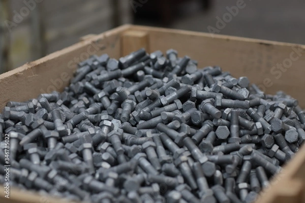 Fototapeta the raw material of the screw and machine producing bolts at the factory 