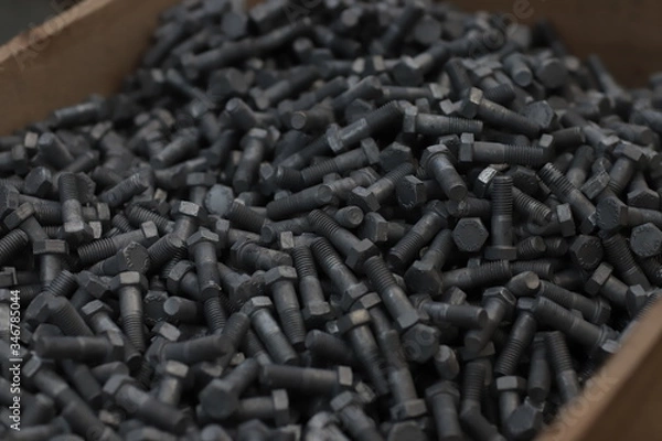Fototapeta the raw material of the screw and machine producing bolts at the factory 