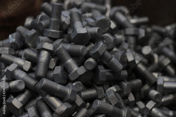 Fototapeta the raw material of the screw and machine producing bolts at the factory 