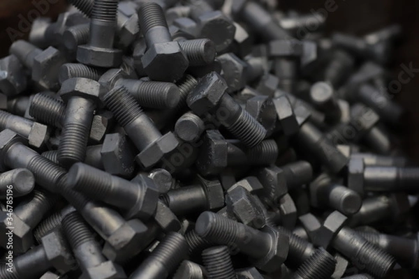 Fototapeta the raw material of the screw and machine producing bolts at the factory 