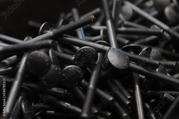 Fototapeta the raw material of the screw and machine producing bolts at the factory 