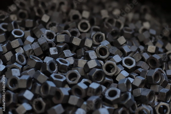 Fototapeta the raw material of the screw and machine producing bolts at the factory 