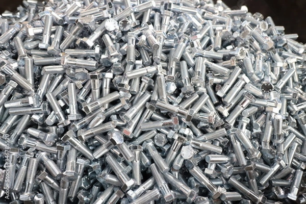Fototapeta the raw material of the screw and machine producing bolts at the factory 