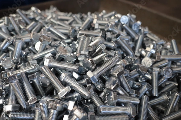 Fototapeta the raw material of the screw and machine producing bolts at the factory 