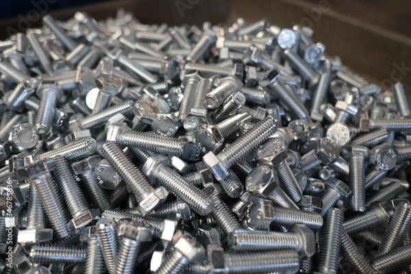 Fototapeta the raw material of the screw and machine producing bolts at the factory 