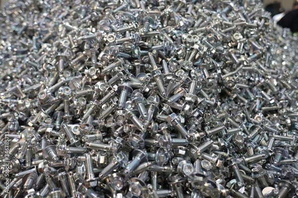 Fototapeta the raw material of the screw and machine producing bolts at the factory 