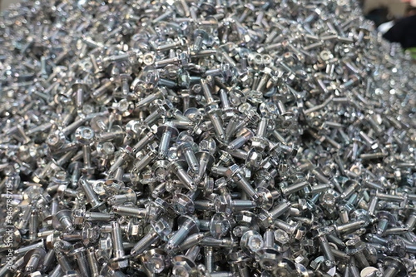 Fototapeta the raw material of the screw and machine producing bolts at the factory 