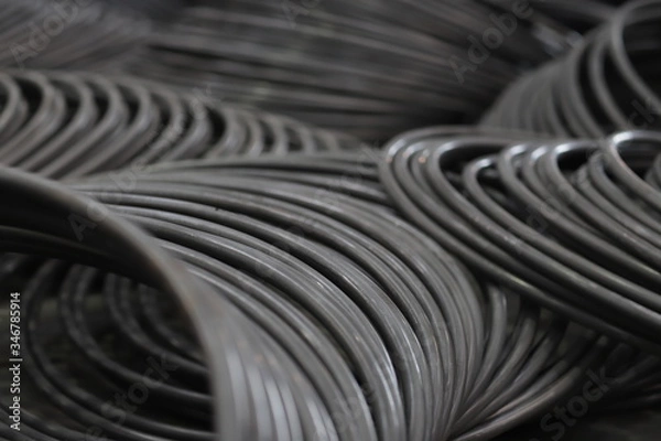 Fototapeta the raw material of the screw and machine producing bolts at the factory 