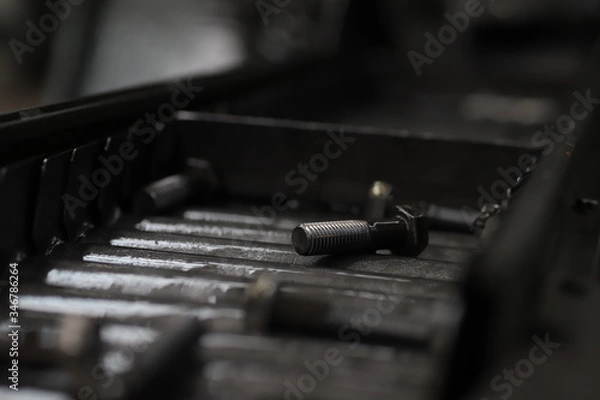 Fototapeta the raw material of the screw and machine producing bolts at the factory 