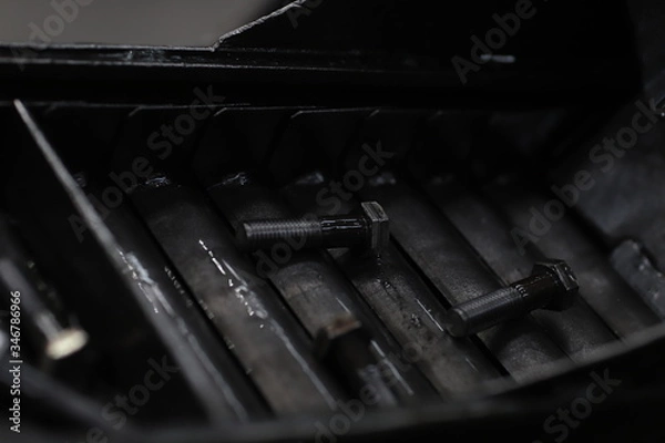 Fototapeta the raw material of the screw and machine producing bolts at the factory 