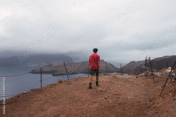 Fototapeta Hiker in the mountains with the sea in the background. Cloudy sky in Ponta de São Lourenço, Madeira. 