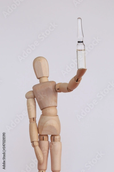 Obraz Wood figurine holding a white vaccine vial