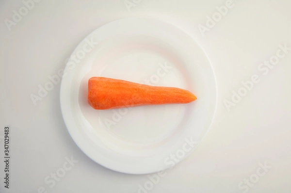 Obraz fresh peeled carrots on a white plate and white isolated background
