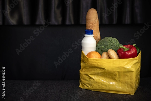 Fototapeta Fruits and vegetables dark background in a Kraft bag from the store. Healthy and healthy food from the farmers ' market. Space for text