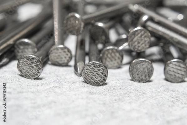 Obraz Head new steel nails on gray cloth close-up.