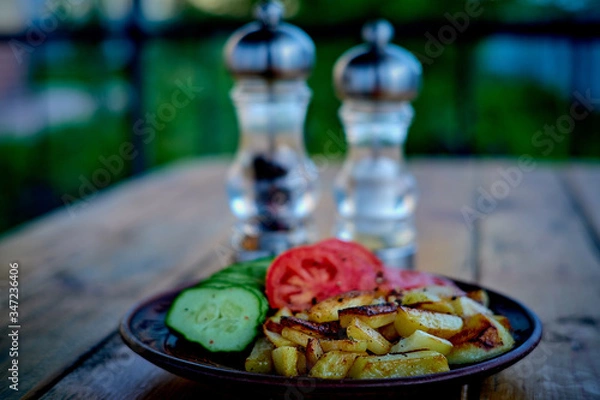 Fototapeta Potatoes, cucumbers and tomatoes on a wooden table.