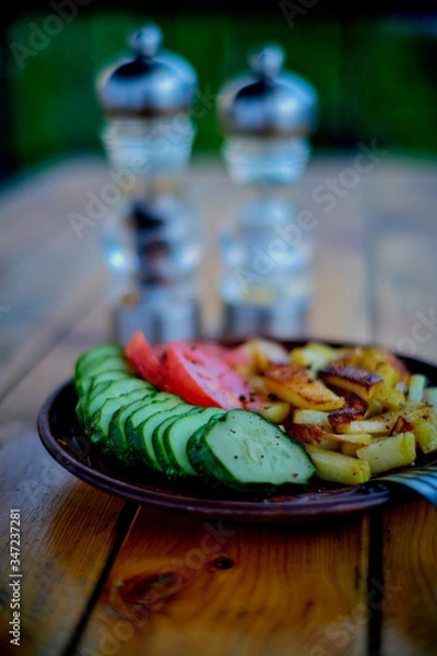 Fototapeta Potatoes, cucumbers and tomatoes on a wooden table.