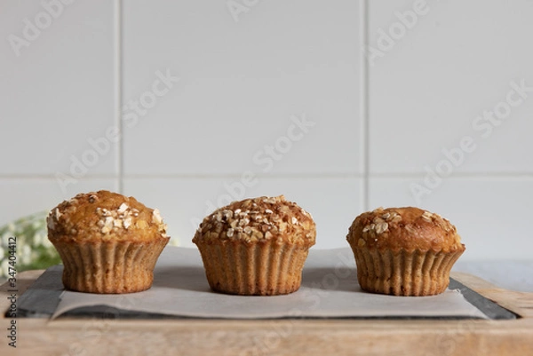 Fototapeta Fresh homemade delicious carrot muffins decorated with oat flakes and brown sugar on rustic table