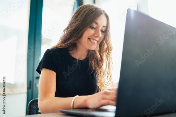 Fototapeta Giovane ragazza lavora e studia da casa