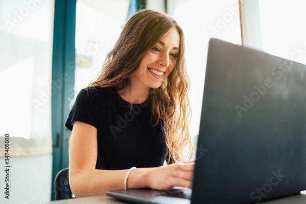 Fototapeta Giovane ragazza lavora e studia da casa