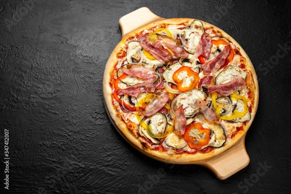Fototapeta SPICY pizza on a black background, tomato-based with mozzarella, sweet pepper, salami, bacon, mushrooms, onion, garlic, eggplant and chili