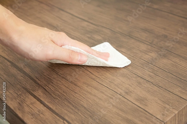 Obraz Cleaning surface. Closeup of hands using tissue paper cleaning wooden table. Concept of disinfection surface to prevent coronavirus infection. Selective focus.