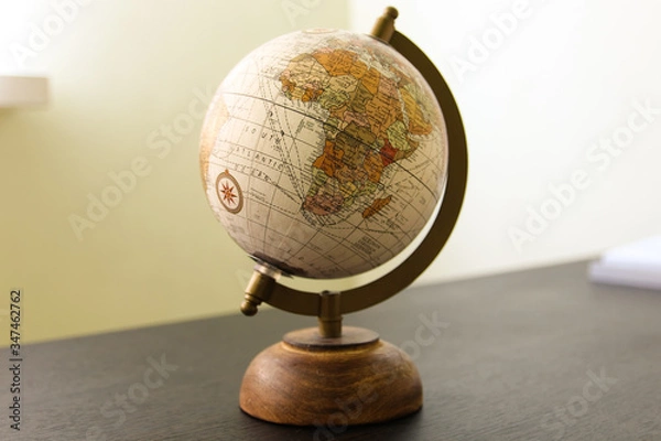 Fototapeta Globe model on the dark wooden table in the room