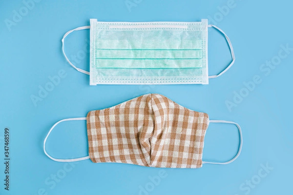 Fototapeta Medical mask and handmade cotton fabric face mask on color background to protection against pollution, flu and Corona virus. Disposable face mask cover mouth and nose. Health care concept. Top view